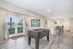 Open recreation area with living space, game tables, and wet bar area